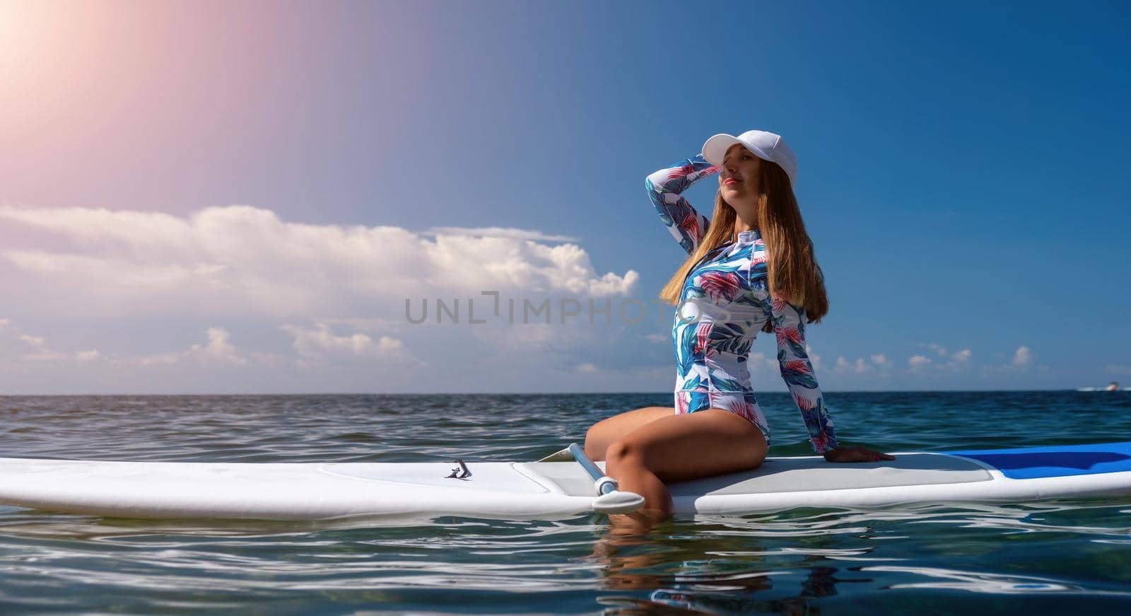 SUP Stand up paddle board. Young woman sailing on beautiful calm sea with crystal clear water. The concept of an summer holidays vacation travel, relax, active and healthy life in harmony with nature