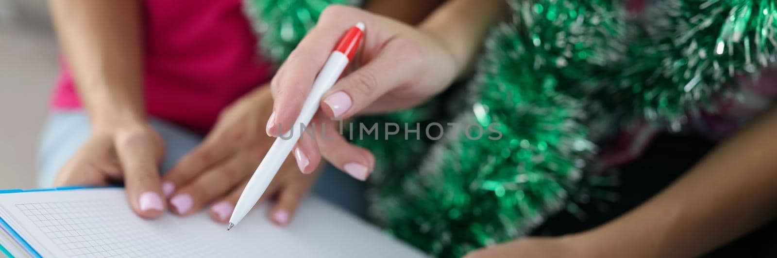 Close-up of woman ready to write ideas for presents, buy gifts for family members, discuss with sister surprises, make notes on paper. Christmas, new year, surprise concept. Blurred background
