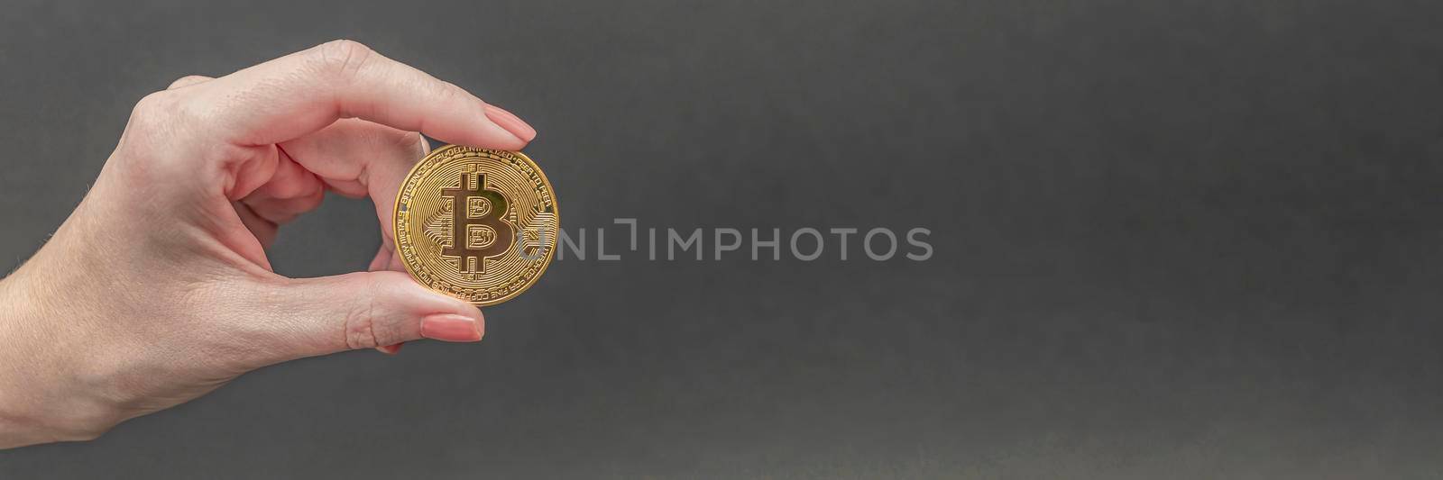 bitcoin in hand, female hand holds a gold bitcoin coin. Cryptocurrency value, digital money, space for text by SERSOL