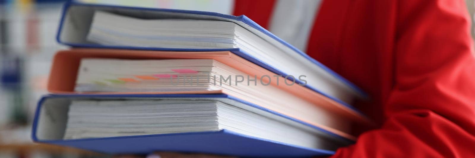 Close-up of office worker carry stack of folders, loaded with work, paperwork, unfinished cases. Task from boss, female clerk, important documents. Business, desk duty concept. Blurred background