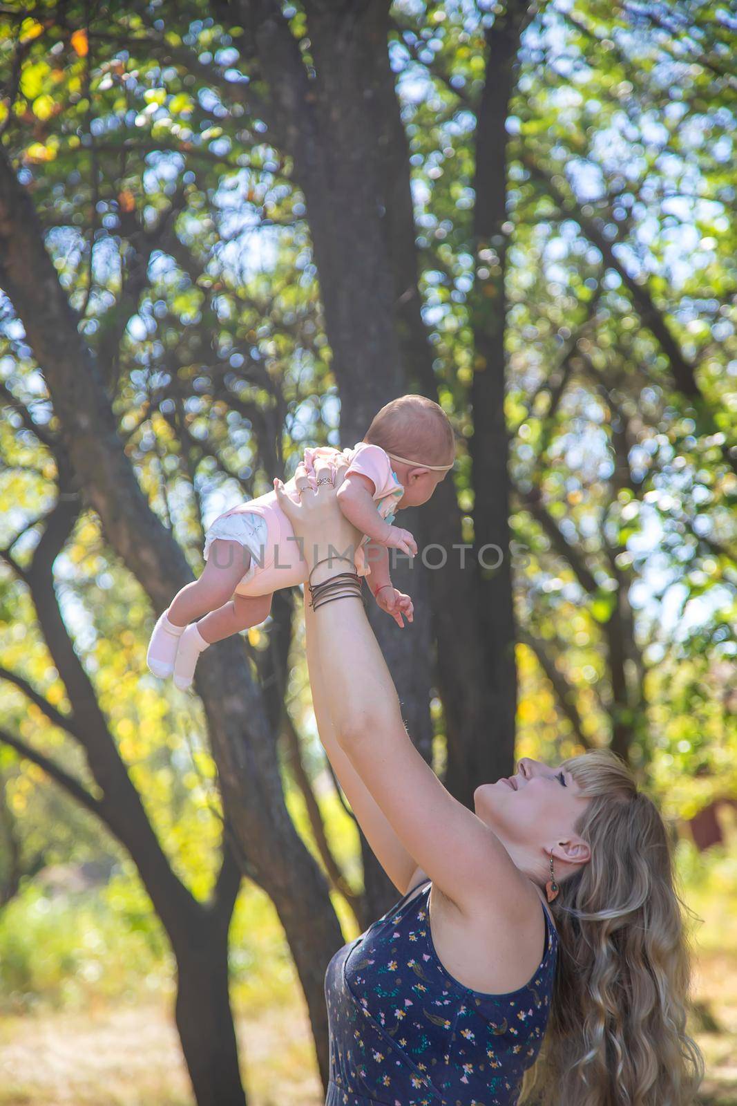 Mom is holding a newborn baby in nature. Selective focus. People.