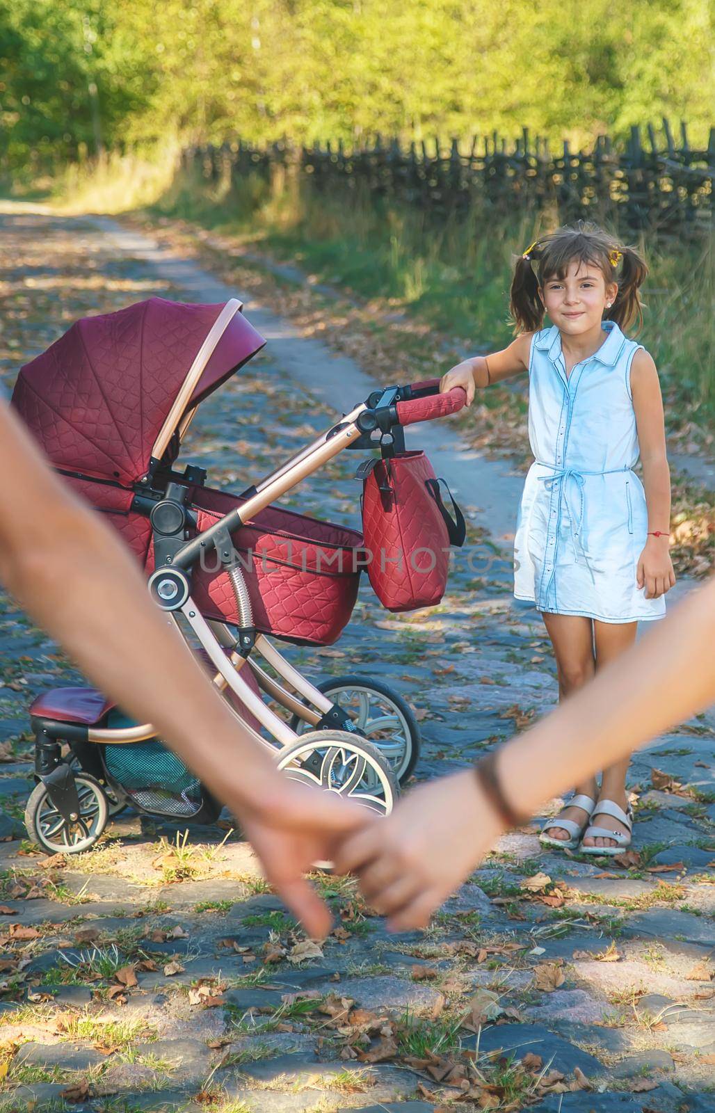 Family photo with a stroller in nature. Selective focus. People.