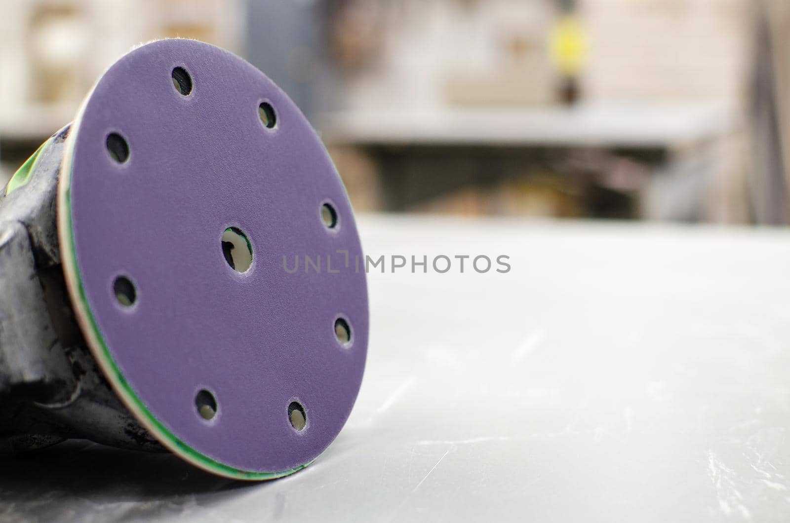Grinding machine for wood on the desktop. Sandpaper lies nearby, production concept.