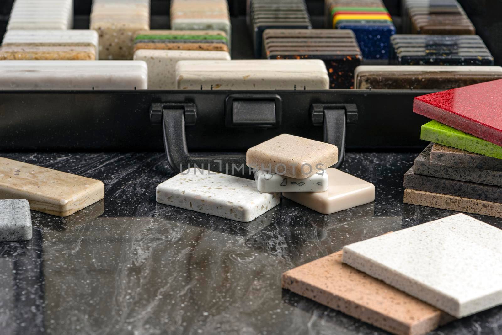 Large selection of stone samples for countertops and floors. Pieces of artificial acrylic stone in a sample box. A set of shades of countertops of different textures.