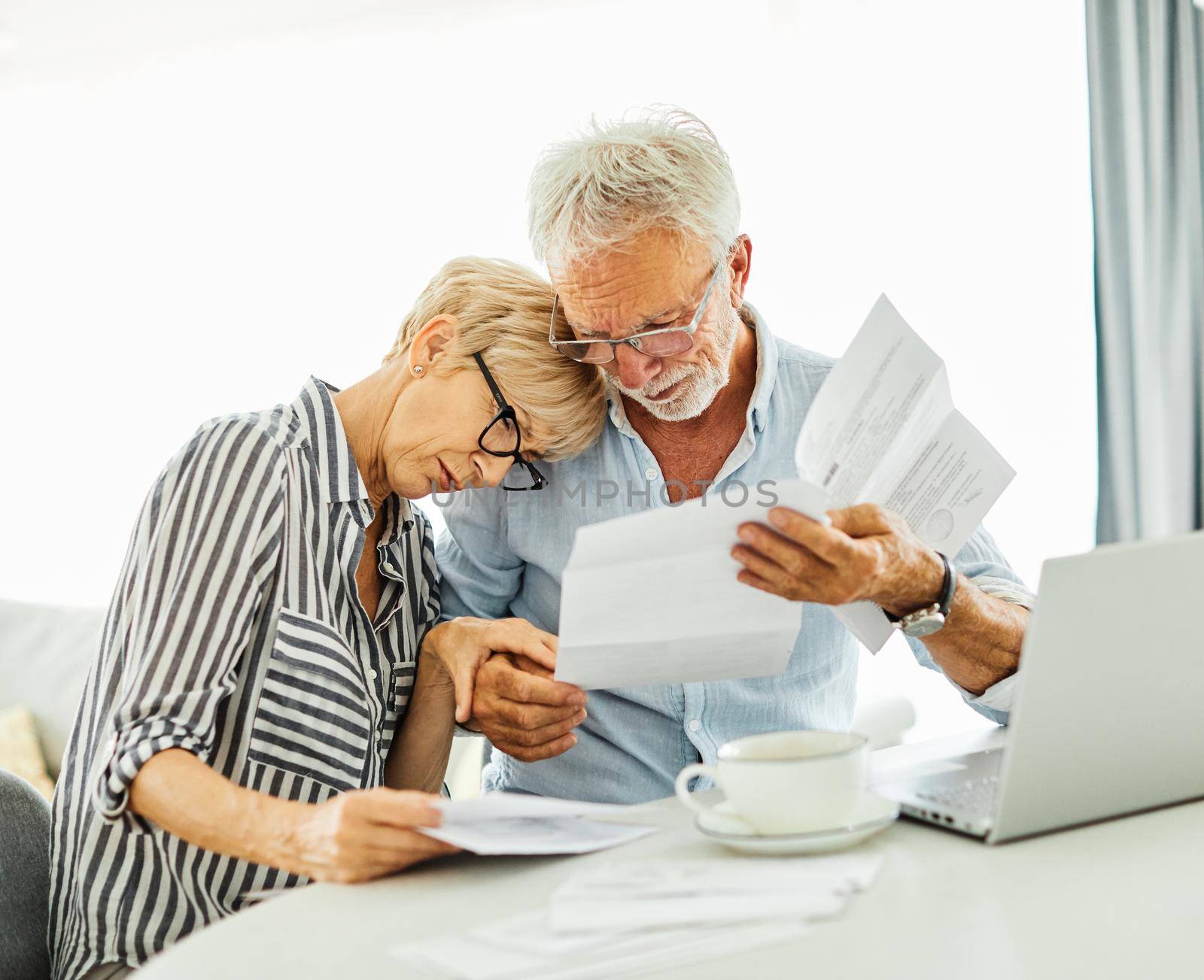 Senior couple checking bills and calculating expenses at home