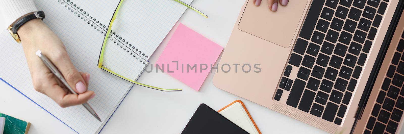 Top view of workplace with laptop device, notebook or planner, stationery, post it notes, smartphone. Working mess on desk, things for work. Technology, productivity, office life, mockup concept