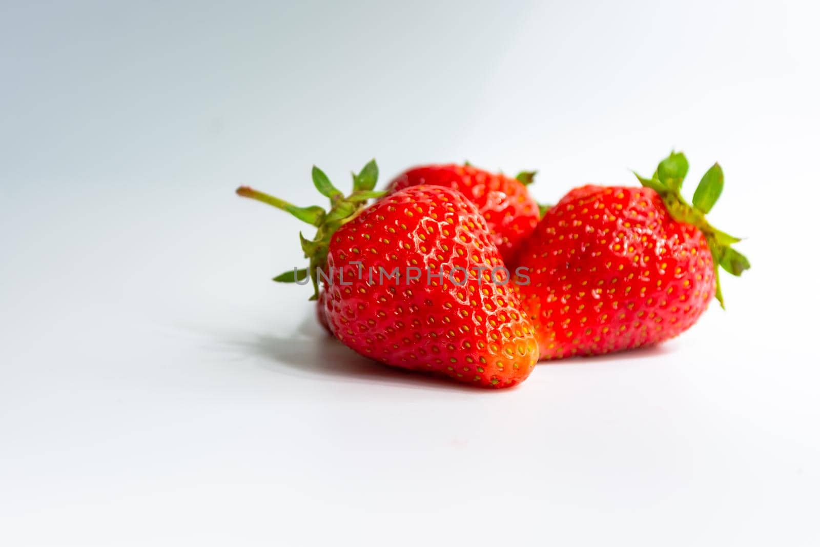 Red ripe juicy strawberries on a white gray background. Sweet natural dessert.
