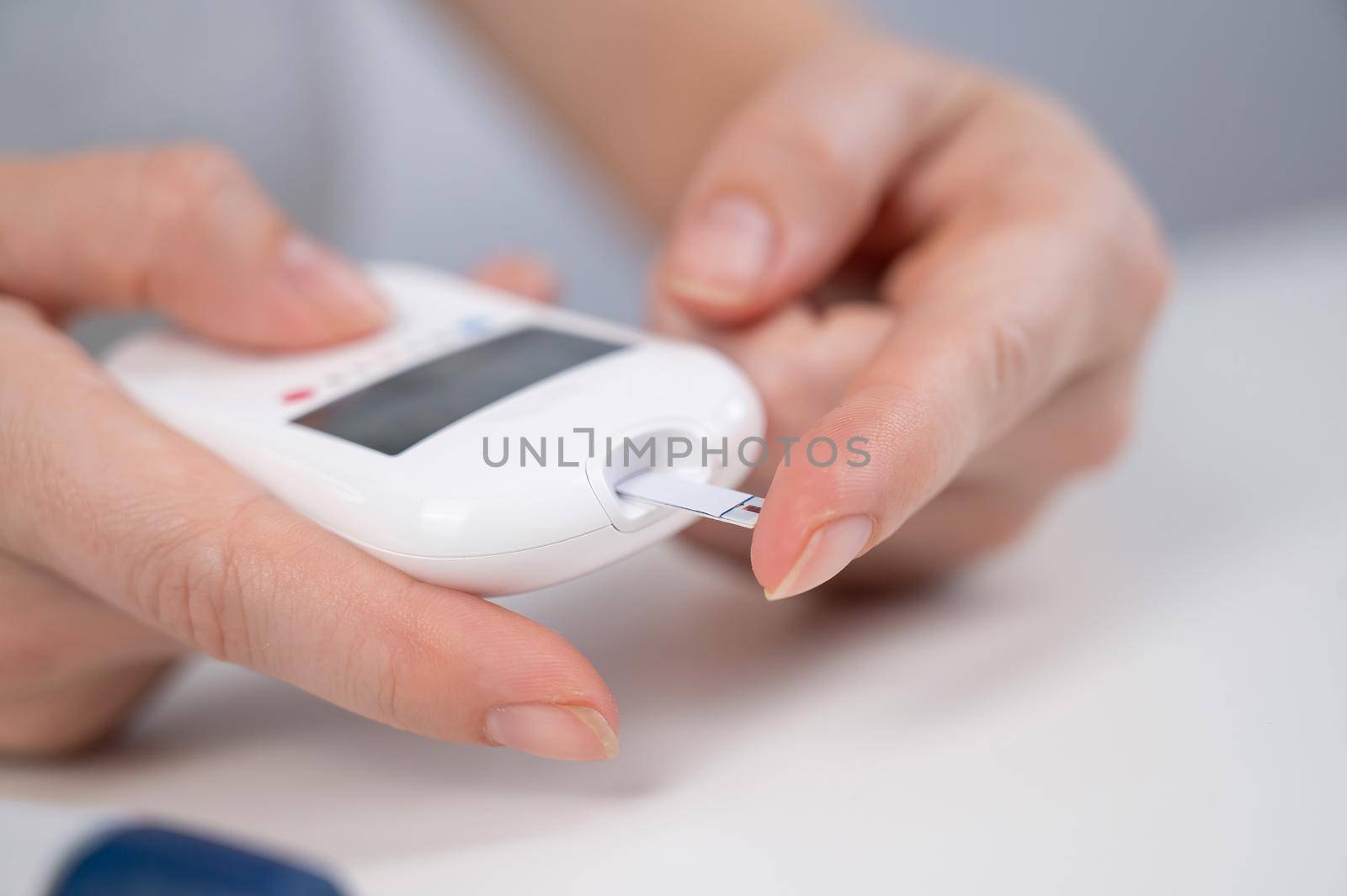 Woman measures blood sugar level with a glucometer