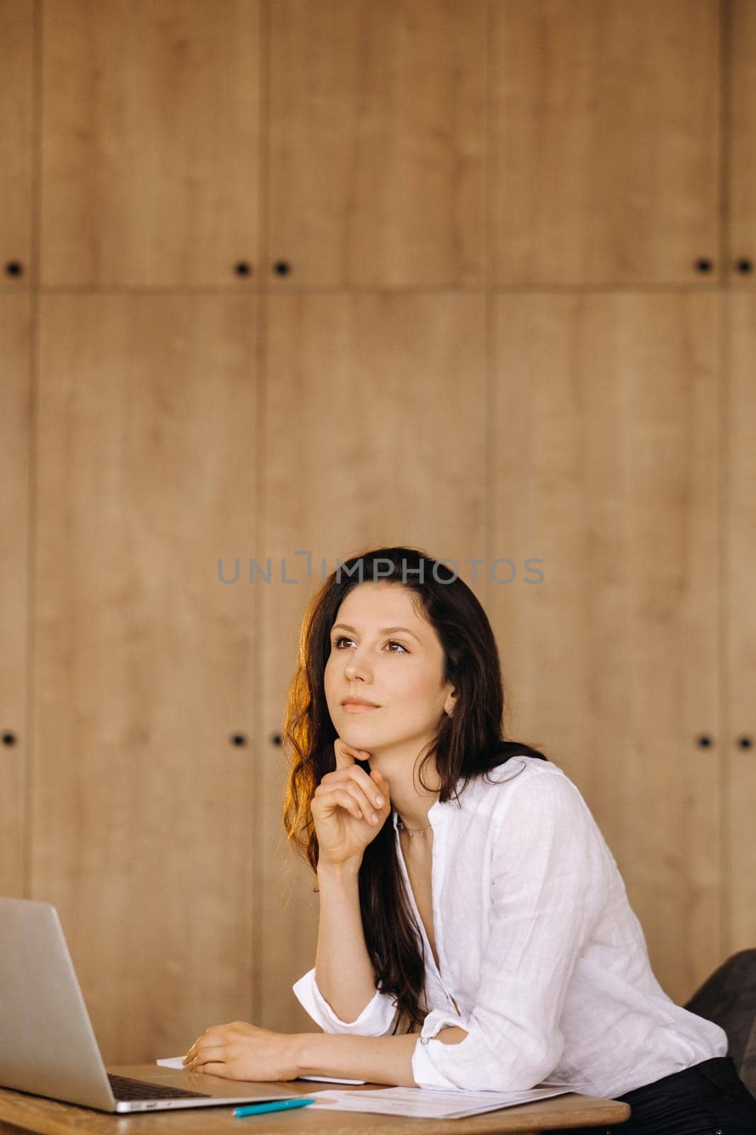 Beautiful woman sitting in the office working on a laptop.