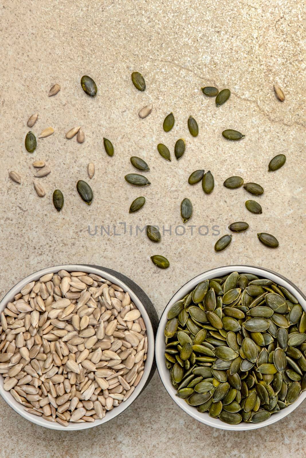 Superfoods, sunflower seeds and pumpkin seeds in a saucer on a marble table top