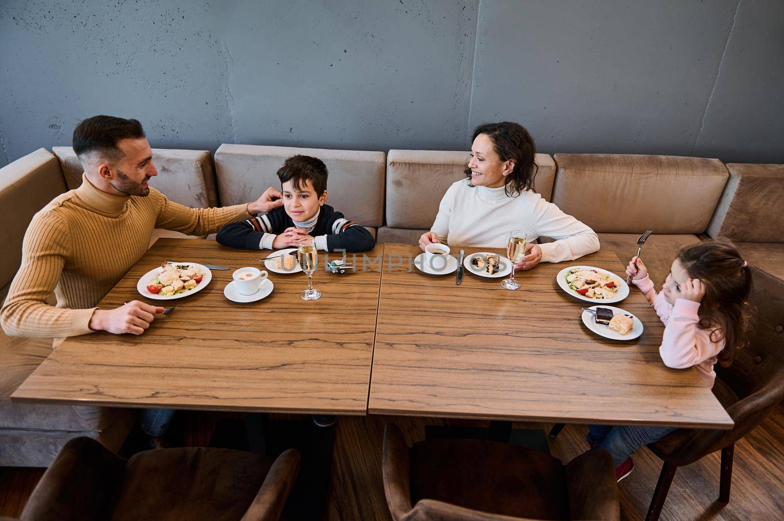 Happy Caucasian family having lunch together in a restaurant. Food and drink concept by artgf