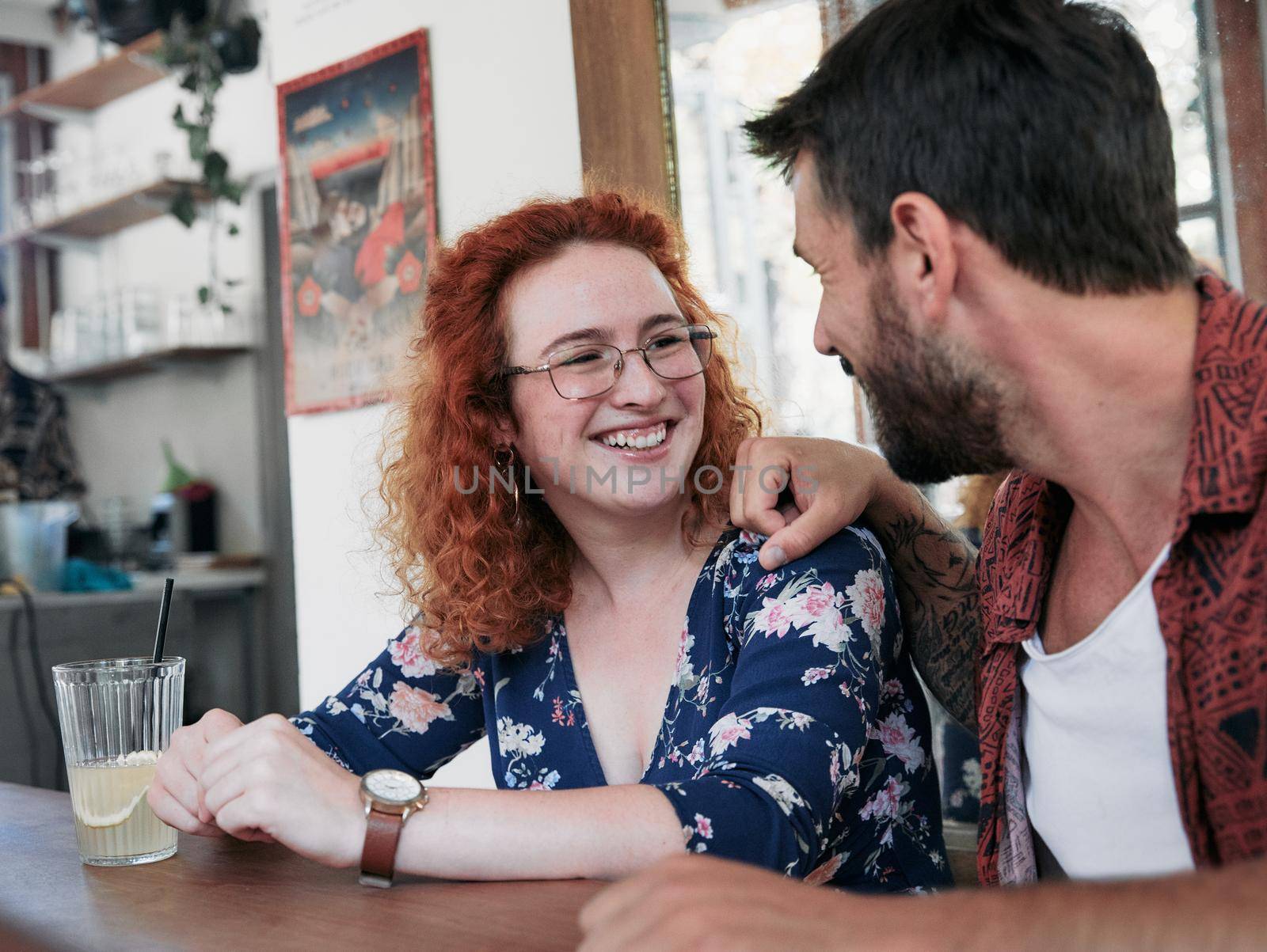 Happy young couple smiling and talking in a coffee shop cafe