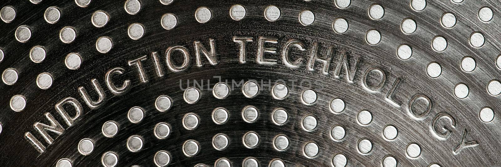 Bottom of induction cookware. Texture of a non-stick induction pan close-up.