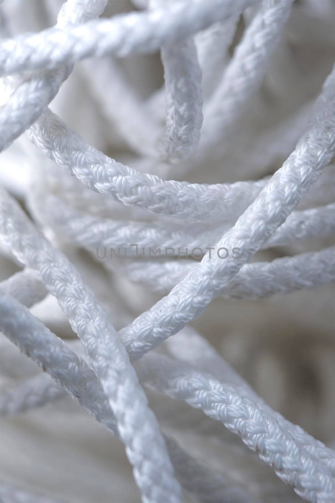 Thick tangled white rope close up. Close-up of an worn out boat rope as a nautical background. by SERSOL