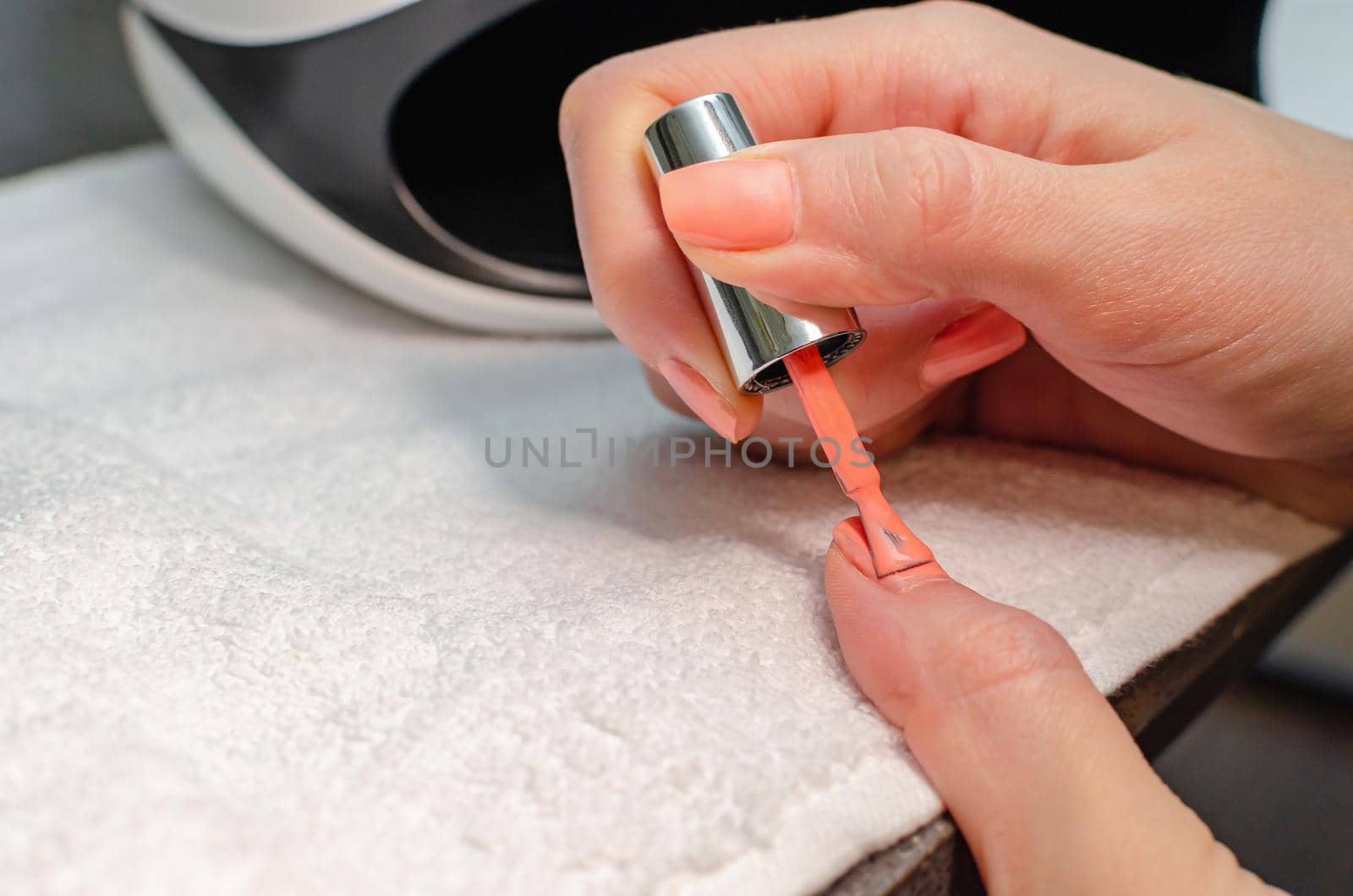 The woman herself does the manicure. Female hands with manicure tools. Nail care concept.