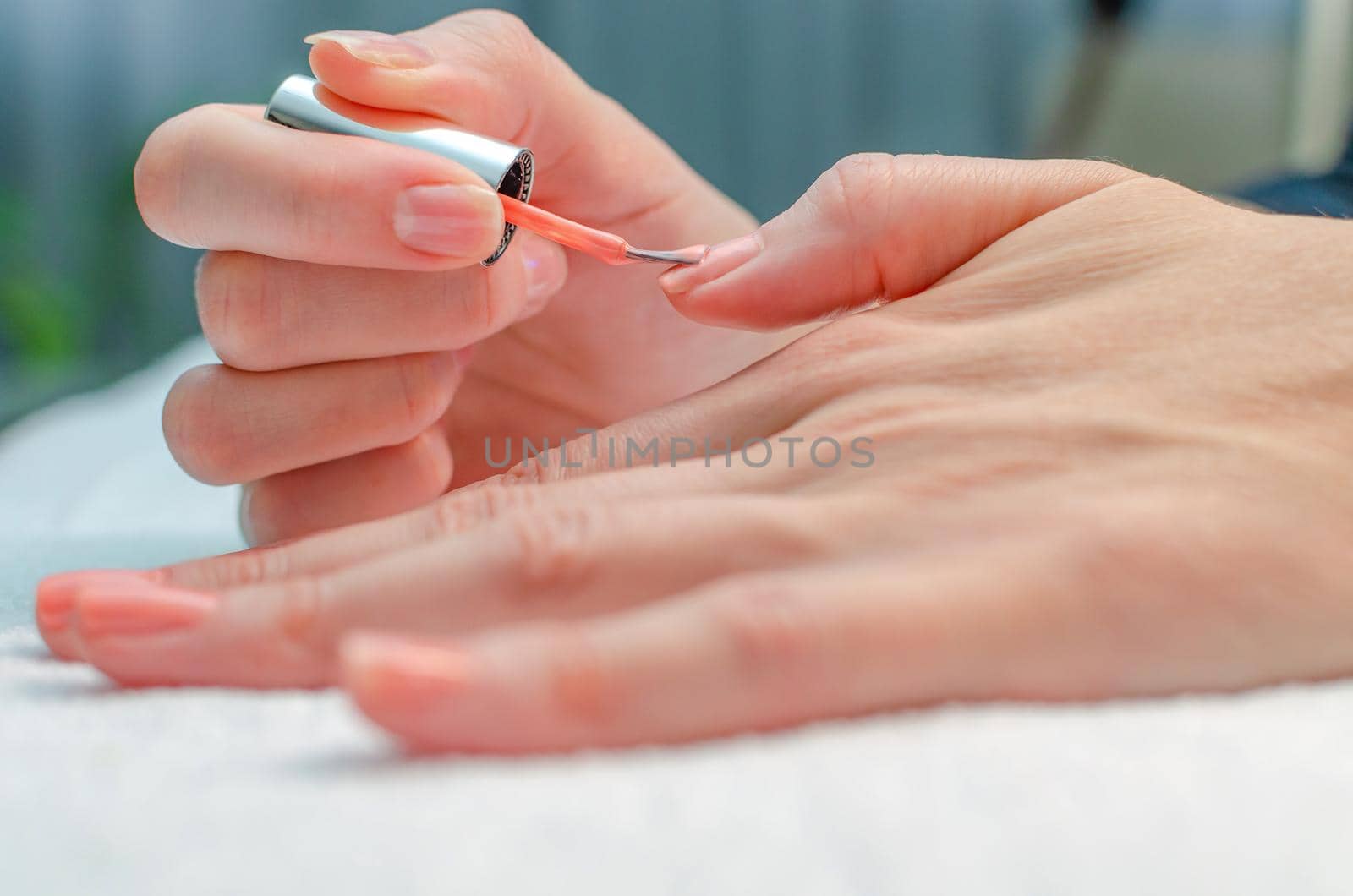 The woman herself does the manicure. Female hands with manicure tools. Nail care concept.