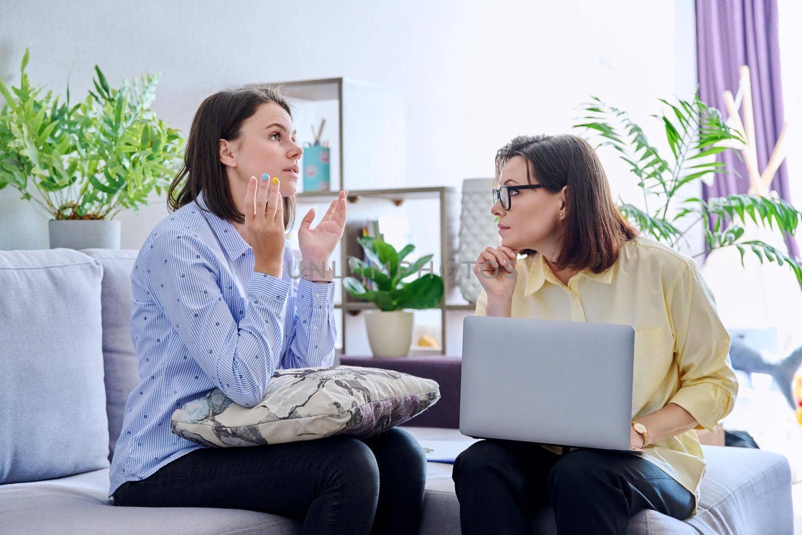 Young woman patient on individual therapy in psychologists office. Mature female counselor listening taking notes talking. Psychology, psychiatry, treatment, mental health concept