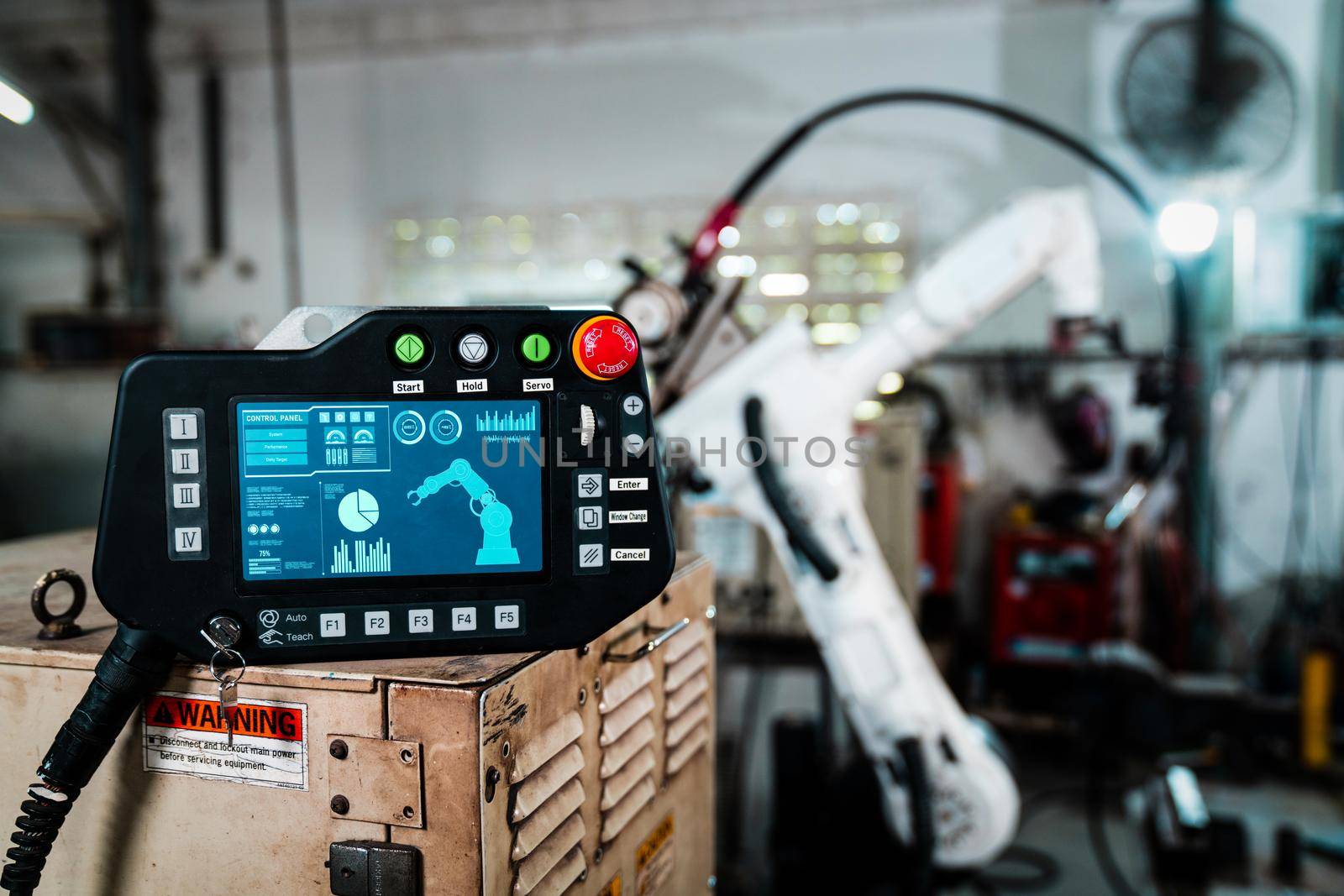 Robotic arm and its controller adept panel in a factory workshop by biancoblue