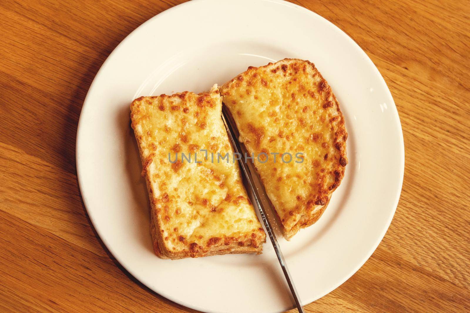 Top view of fat Sandwich toast with ham, cheese and tomato on plate on a wooden background