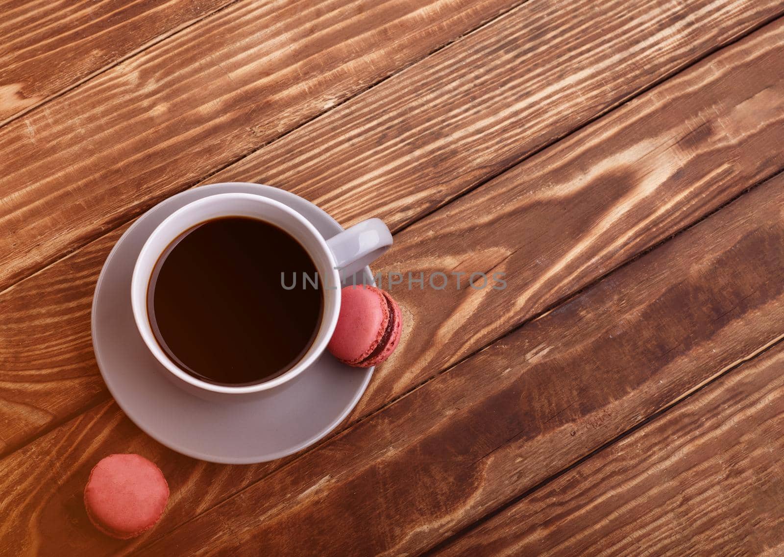 purple cup of coffee with macaroons on the wooden background