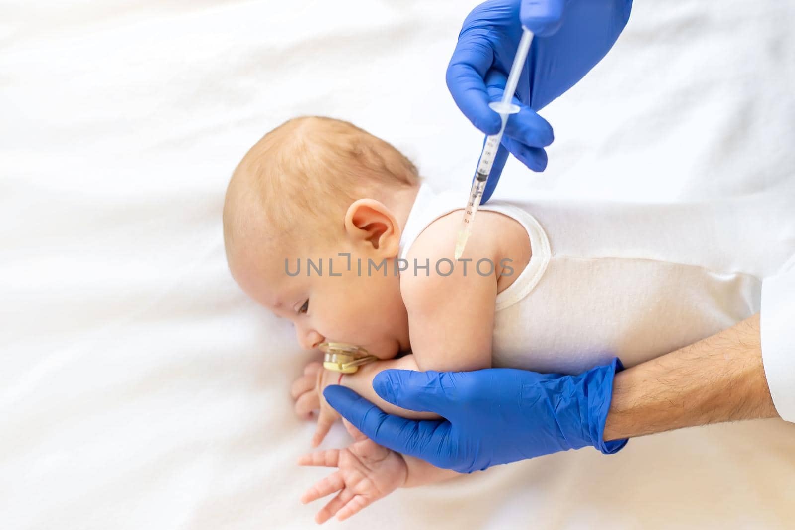 Vaccination baby, injection in the arm. Selective focus. People.