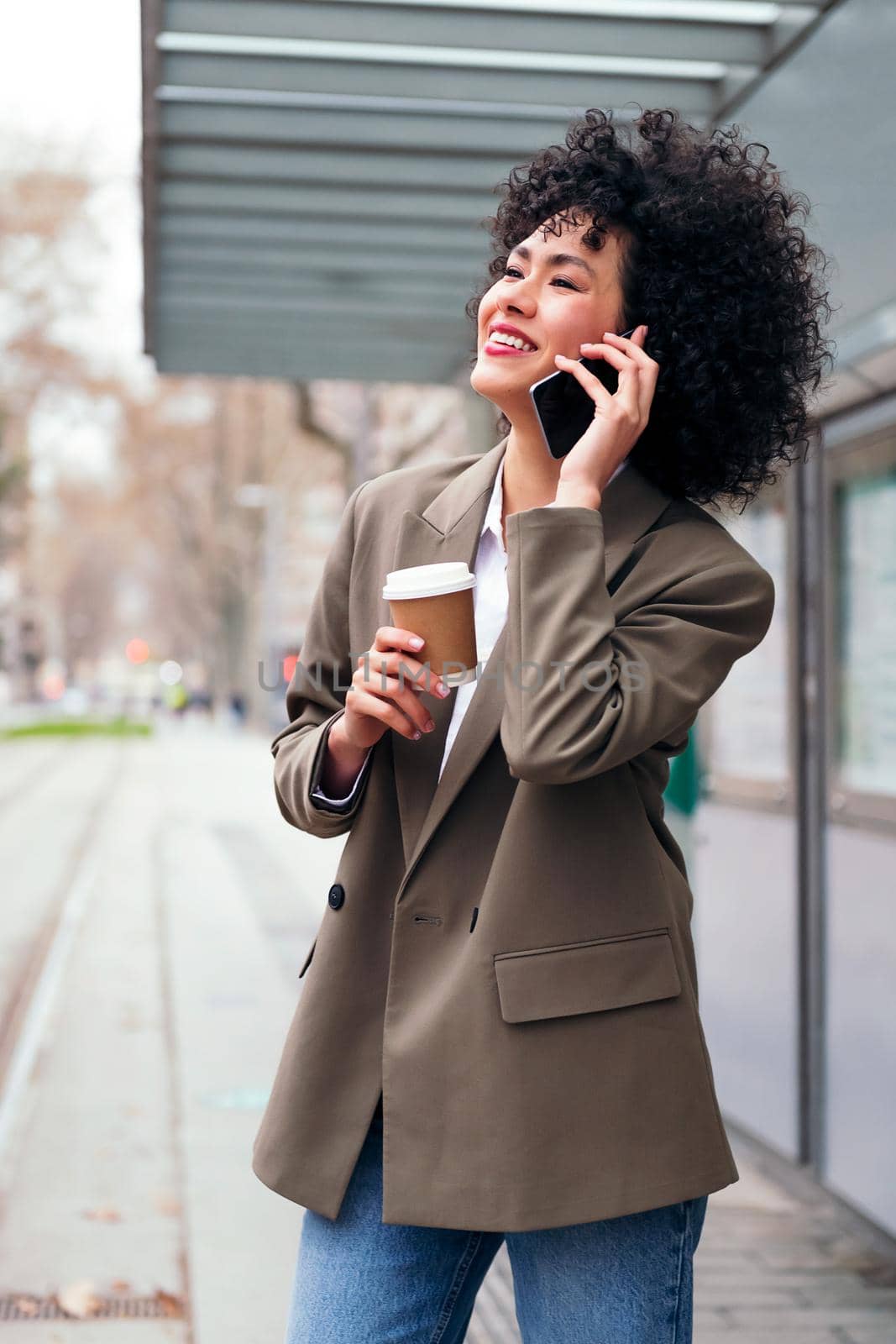 young latin businesswoman talking happy on the phone outdoors, concept of communication and urban lifestyle