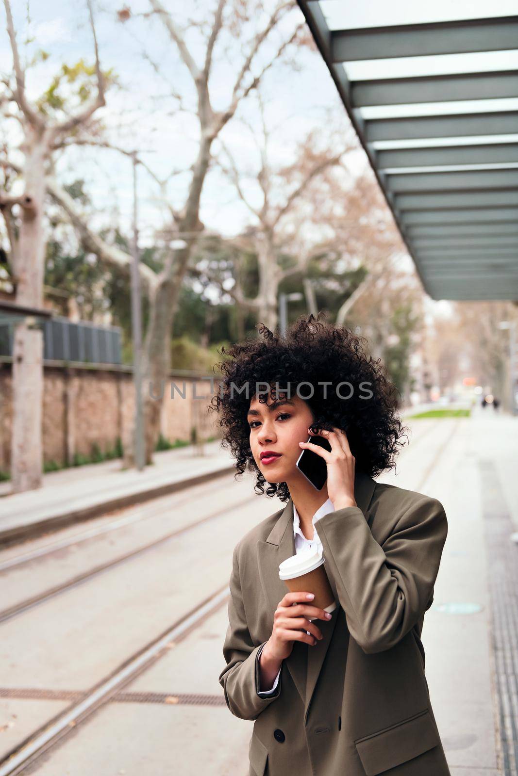woman talking by phone while waiting for the tram by raulmelldo