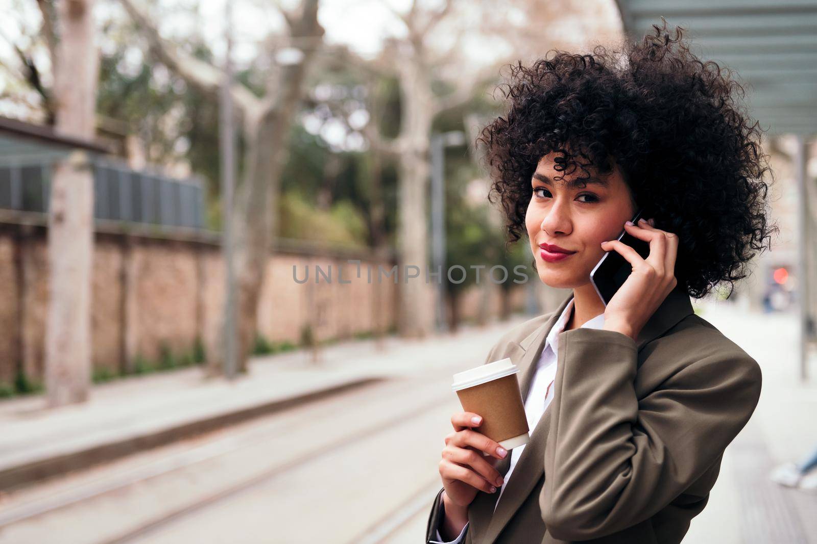 young latin businesswoman talking on the phone outdoors, concept of communication and urban lifestyle