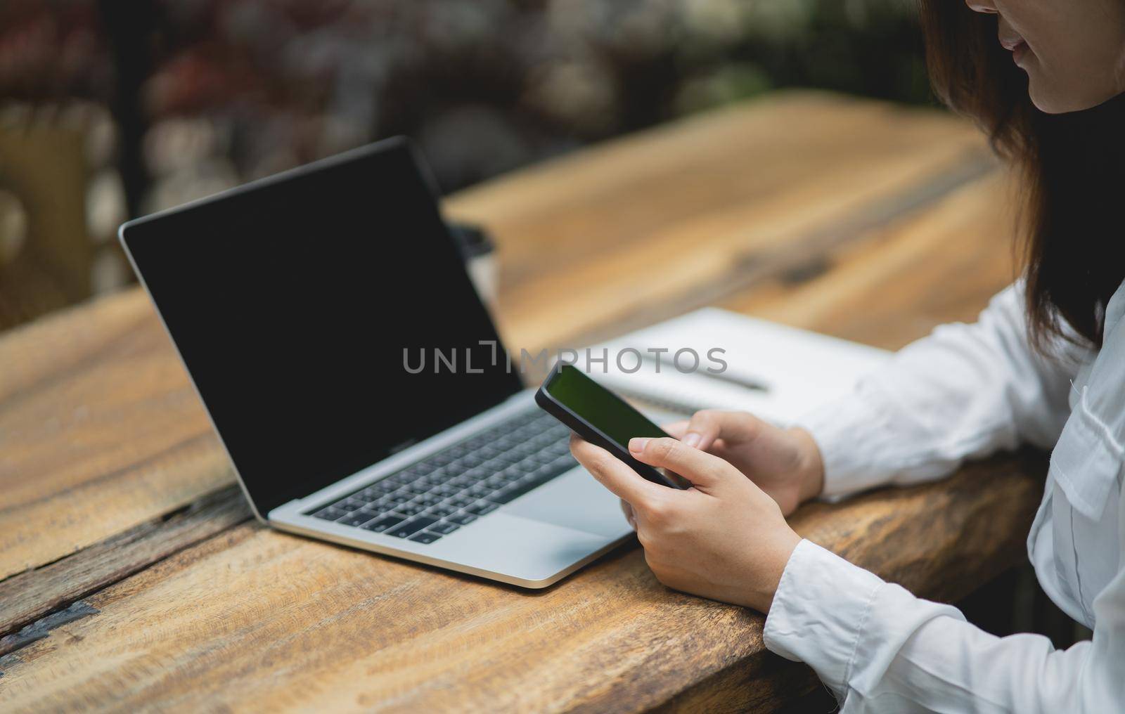 woman hold mobile phone text or message. Businesswoman use smartphone to browse web, working laptop, trade stocks.