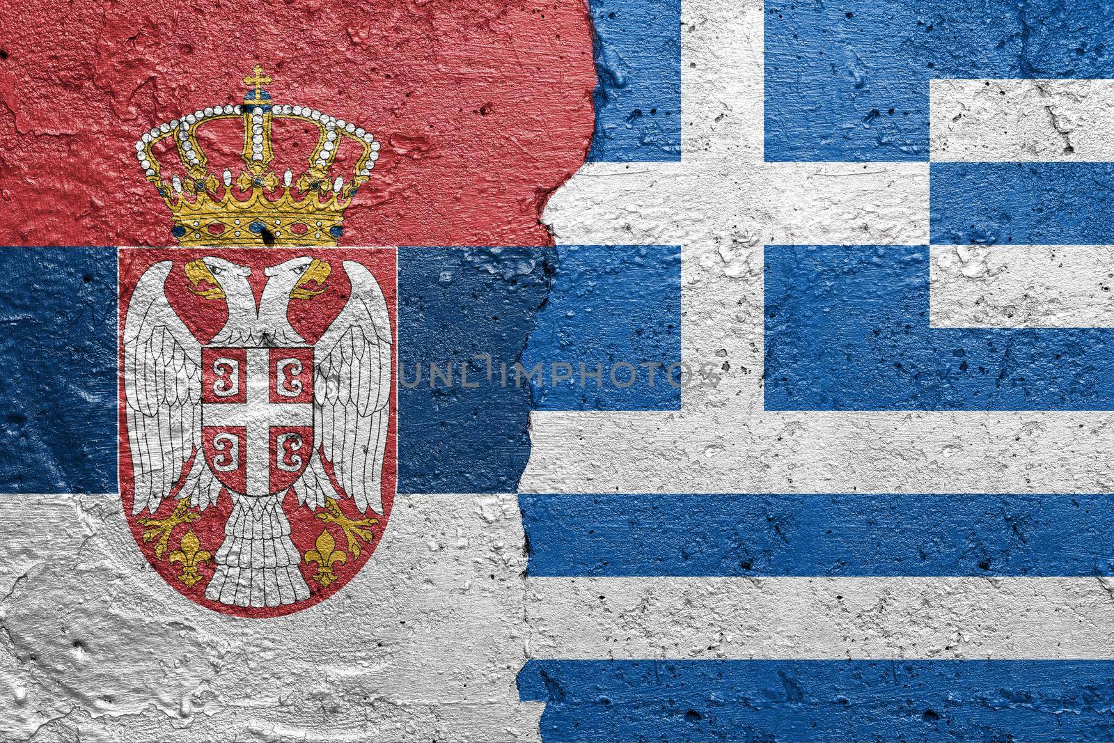Serbia and Greece - Cracked concrete wall painted with a Serbian flag on the left and a Greek flag on the right stock photo by adamr