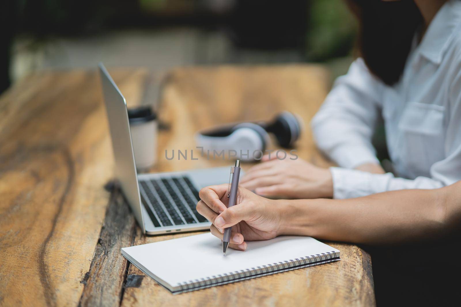 Business man use pen point to laptop and business woman coworkers working with laptop together in modern cafe.business partners discussing new startup project. by Wmpix