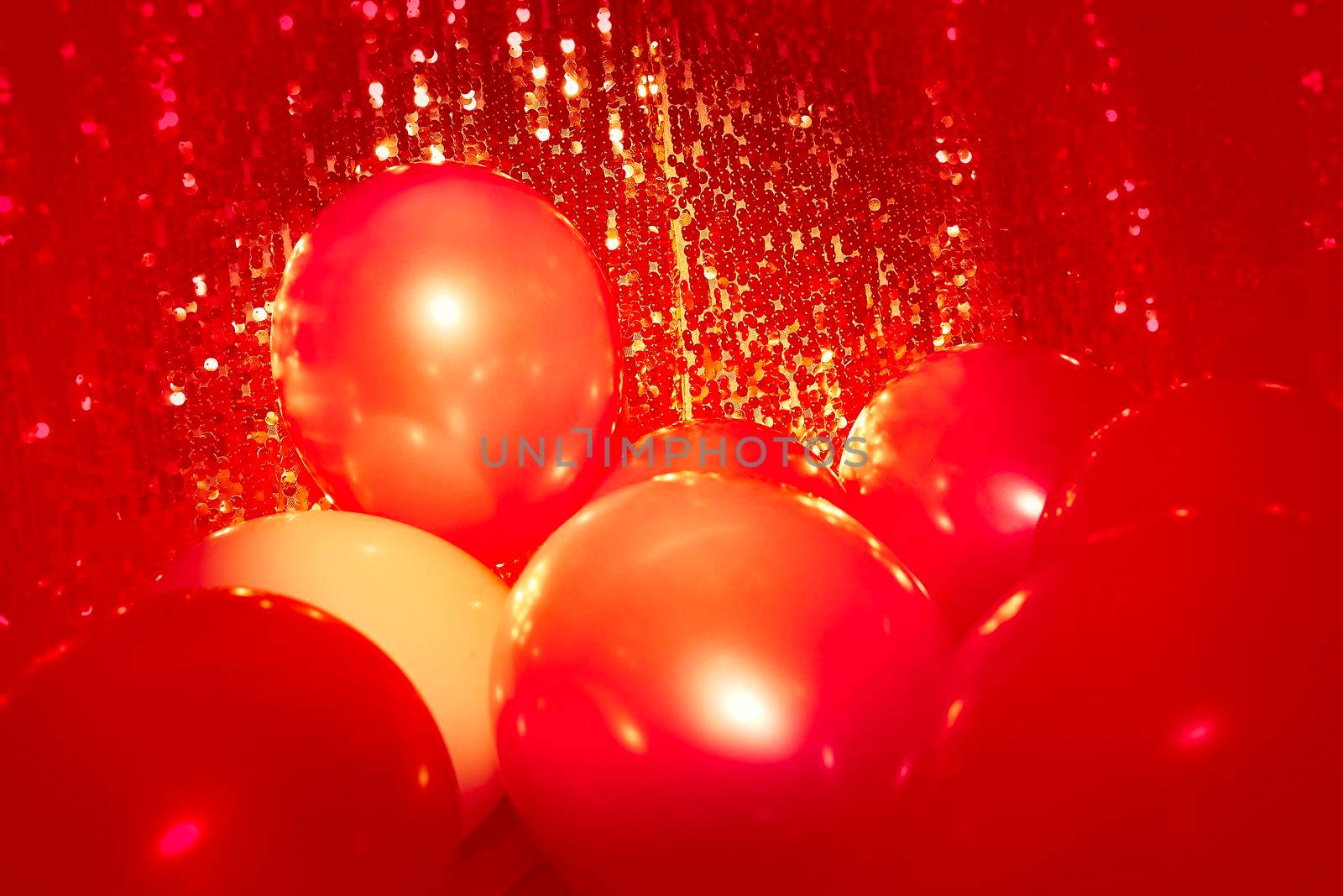 a brightly colored rubber sac inflated with air and then sealed at the neck, used as a children's toy or a decoration. Red world. Red balloons on a red background. High quality photo