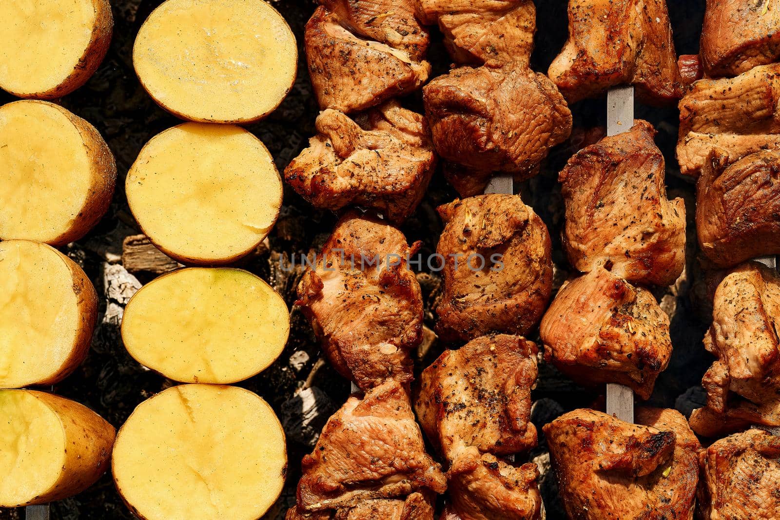 A meal or gathering at which meat, fish is cooked out of doors on a rack over an open fire or on a portable grill. Delicious piece of meat fried over the fire at a picnic. . High quality photo