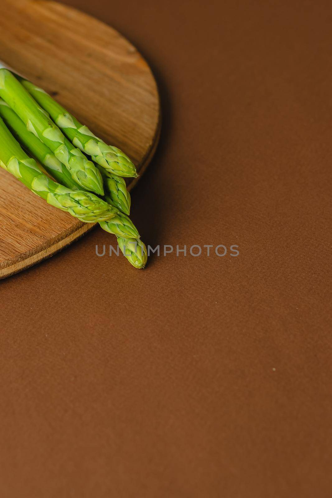 branches of fresh green asparagus on a wooden background, top view