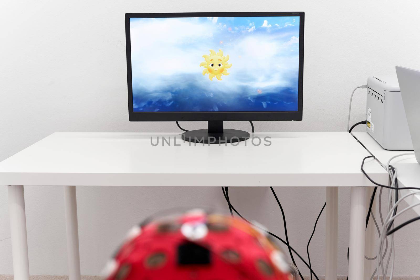 Unrecognizable patient looking at a screen with a picture of a sun during a biofeedback session