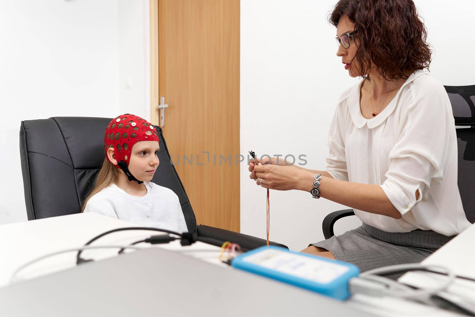Doctor holding electrodes to put a girl through biofeedback session by WesternExoticStockers