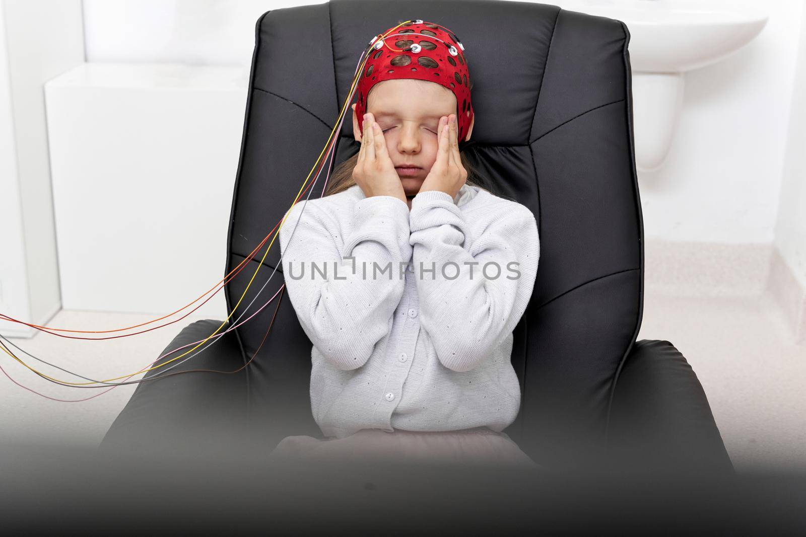 Young girl gesturing fatigue while looking at a screen during a biofeedback therapy
