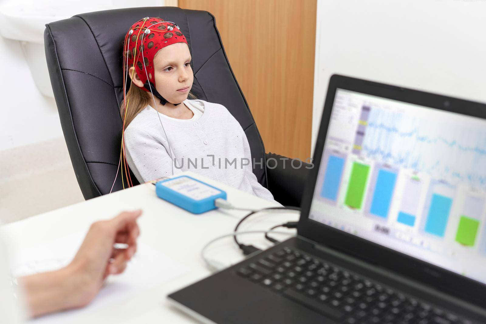 patient sitting in a chair during biofeedback therapy while being monitored by a doctor