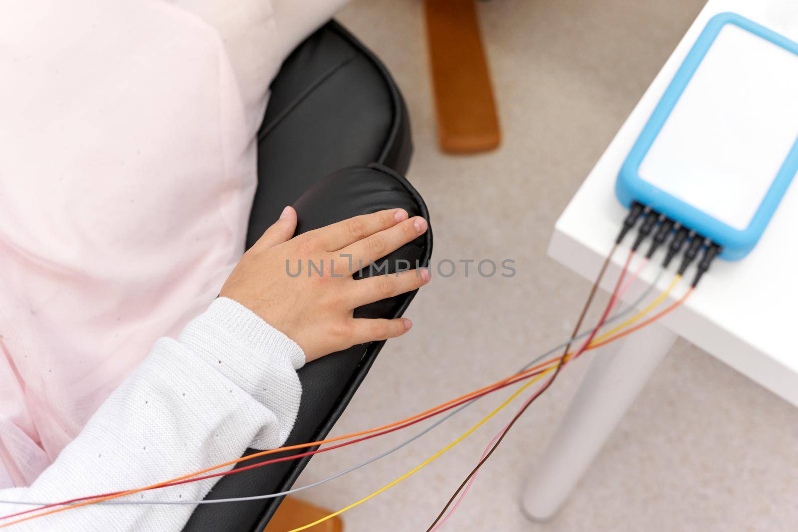 Relaxed arm of a patient connected to a device during a biofeedback session by WesternExoticStockers