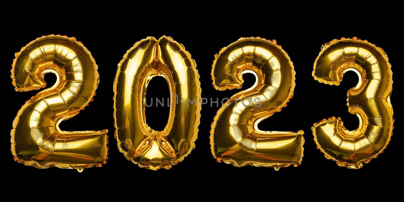 2023 Happy New Year concept from golden foil balloon on black by adamr