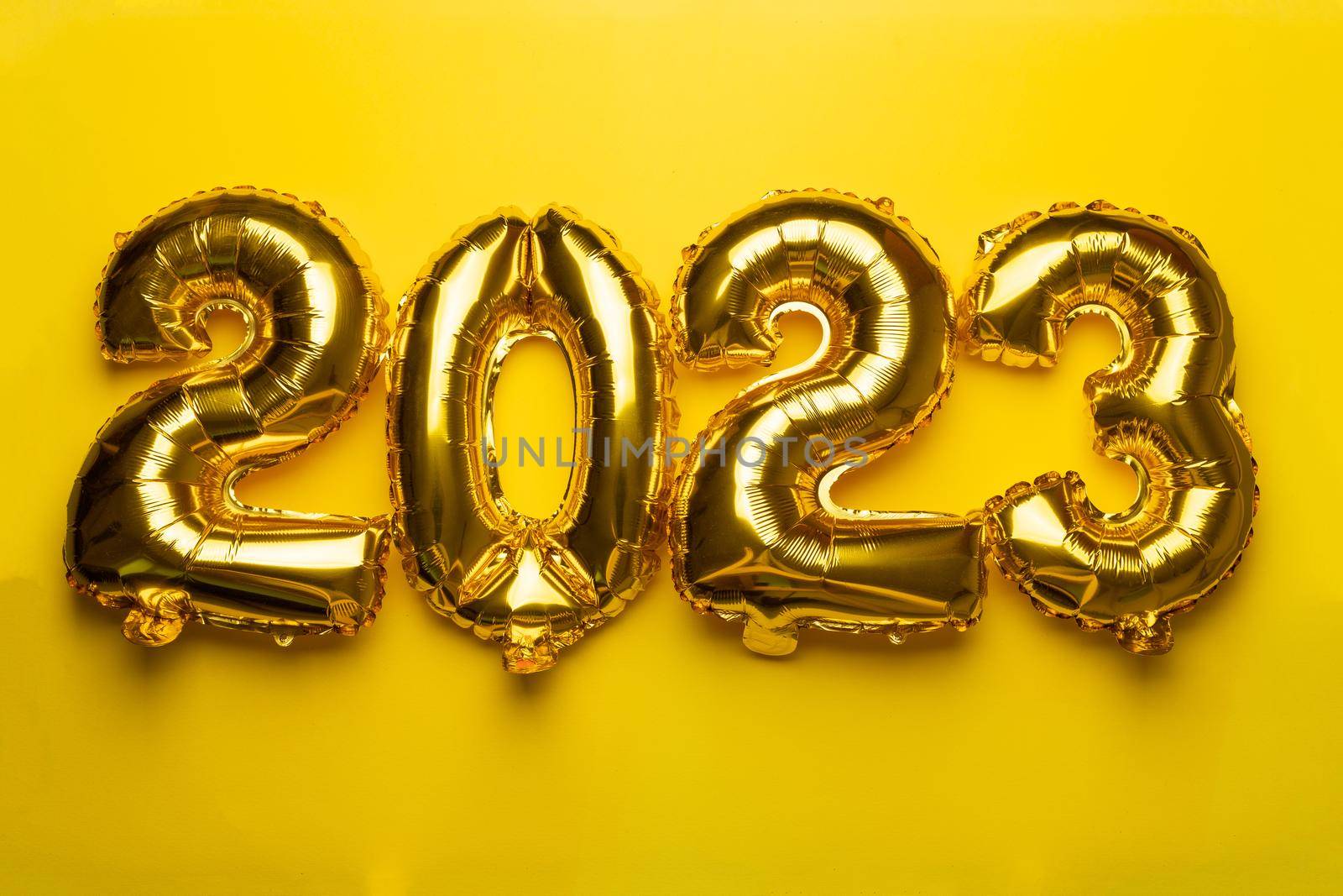 2023 Happy New Year concept from golden foil balloon by adamr