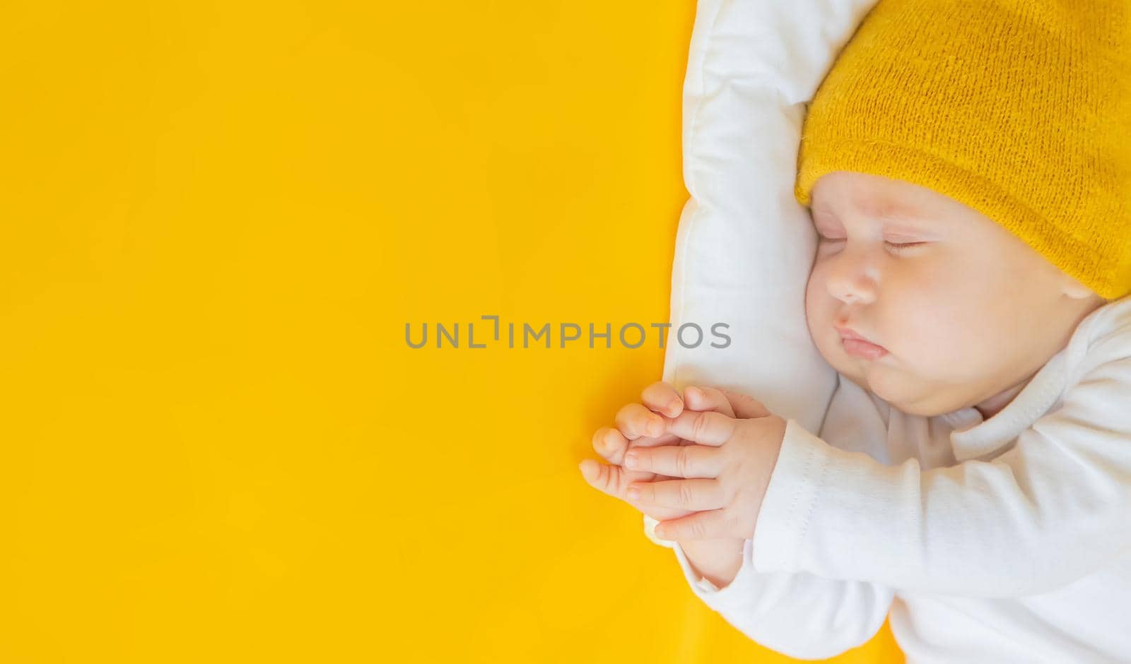 Baby sleeps on a yellow background. Selective focus. People. Merry Christmas and Happy New Year, Holidays greeting card background. Selective focus.