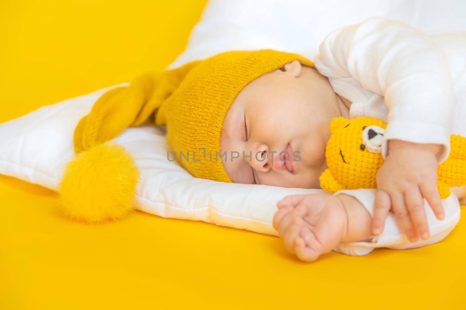 Baby sleeps on a yellow background. Selective focus. People. Merry Christmas and Happy New Year, Holidays greeting card background. Selective focus.