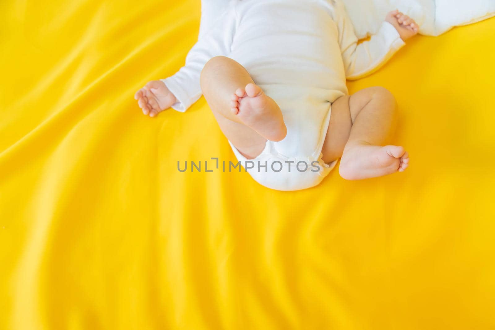 Baby feet on a yellow background. Selective focus. People. Merry Christmas and Happy New Year, Holidays greeting card background. Selective focus.