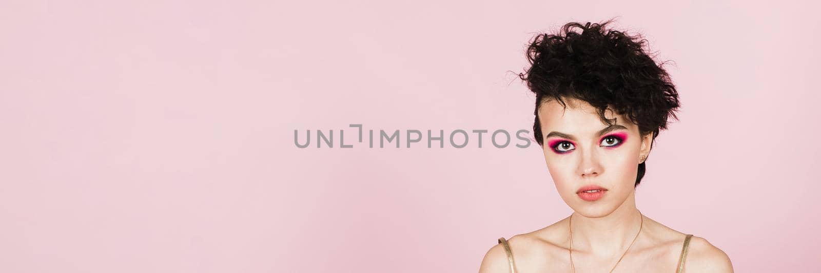 The joy of dressing. Beautiful pleased cheerful American young woman wearing stylish, posing at the camera in studio. Web banner.