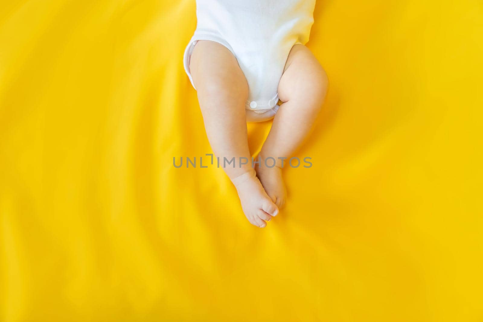 Baby feet on a yellow background. Selective focus. People. Merry Christmas and Happy New Year, Holidays greeting card background. Selective focus.