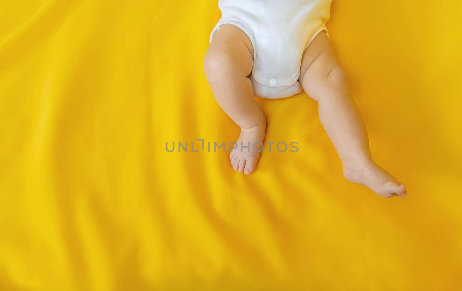 Baby feet on a yellow background. Selective focus. People. Merry Christmas and Happy New Year, Holidays greeting card background. Selective focus.