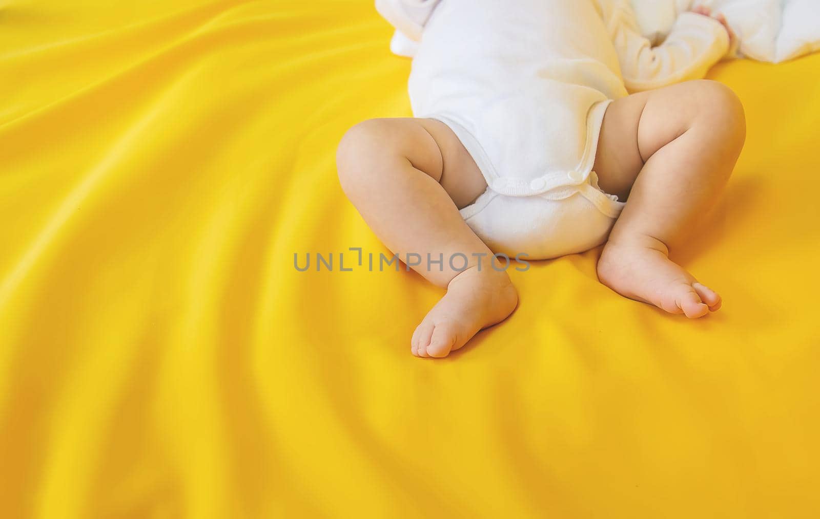 Baby feet on a yellow background. Selective focus. by yanadjana