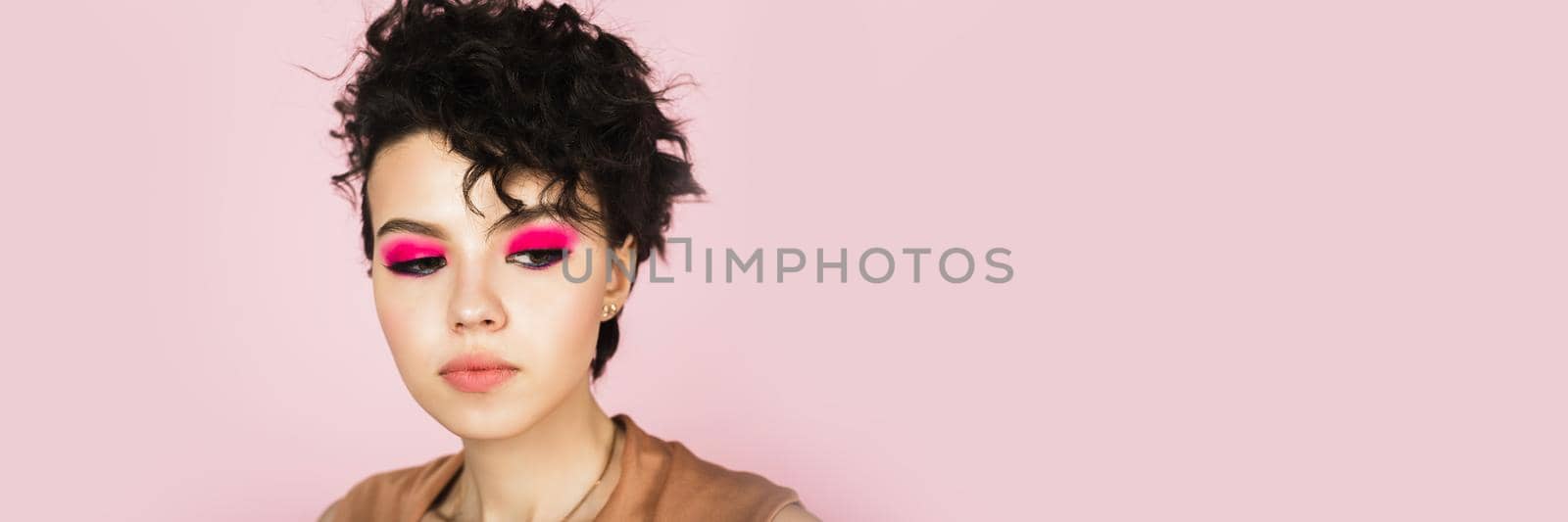 Portrait of a beautiful model with bright pink make-up and bright flying hair. Beautiful lips and makeup. Sexy girl with short hair. Web banner.