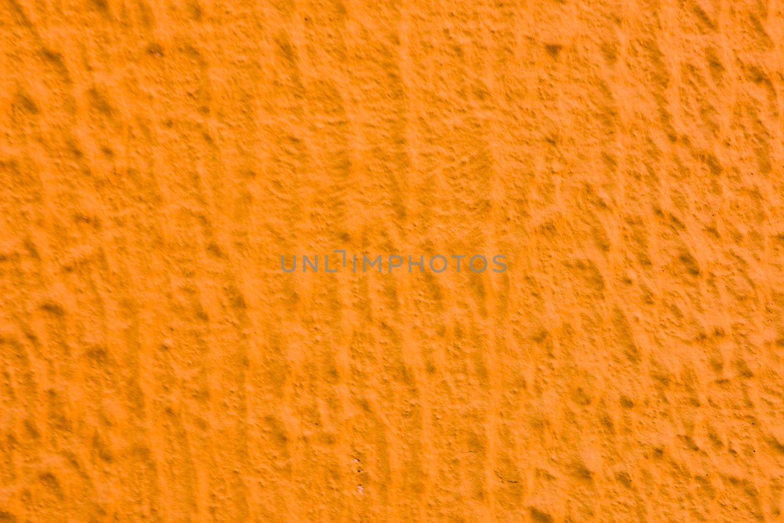 Relief texture of orange paint on the wall.